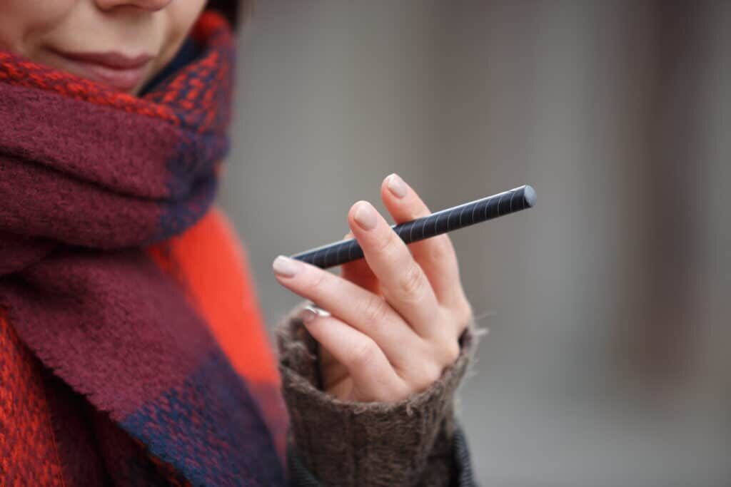 Photo of individual holding a disposable vape product